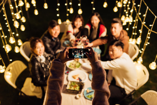 Group of friends having dinner together and taking photos