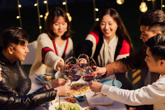 Group of friends having dinner together in a backyard