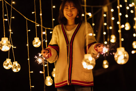 Young girl playing with sparklers in backyard on new year's eve