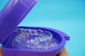 clear plastic retainer teeth in the box set isolated on blue sky background. it's an equipment for orthodontist give the patient to orthodontic surgery in dental clinic or hospital