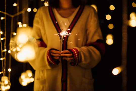 Young girl playing with sparklers in backyard on new year's eve