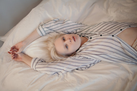 Young human in shirt lying on linen