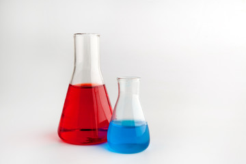 glass test-tubes with colored liquid and smoke at green background