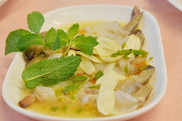 Raw shrimp in fish sauce and spicy sauce with vegetable on plate.