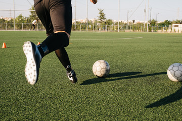 Crop soccer player kicking ball