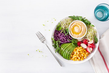 vegan avocado sweet corn lunch bowl with hummus, red cabbage, radish and sprouts