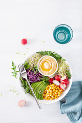 vegan avocado sweet corn lunch bowl with hummus, red cabbage, radish and sprouts