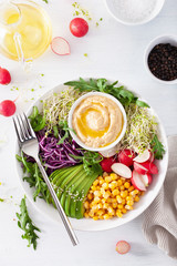vegan avocado sweet corn lunch bowl with hummus, red cabbage, radish and sprouts