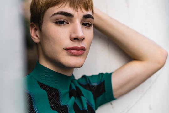 Young confident androgyne man in striped shirt