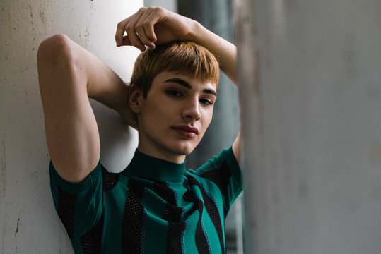 Young confident androgyne man in striped shirt
