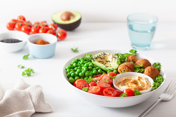healthy vegan lunch bowl with falafel hummus tomato avocado peas