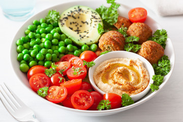 Fototapeta na wymiar healthy vegan lunch bowl with falafel hummus tomato avocado peas