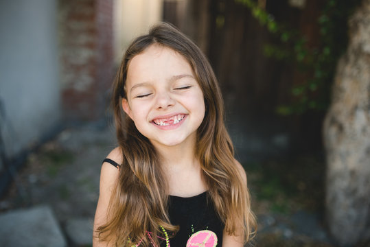 A candid portrait of a girl missing her teeth