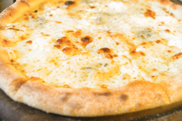 Sliced italian pizza with cheese on wooden table