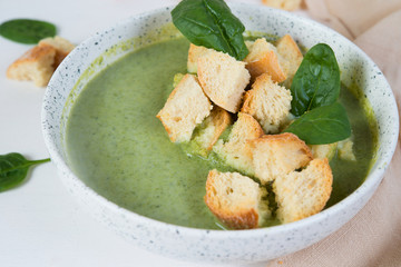 Vegetarian broccoli and spinach soup with croutons. Green healthy food concept.