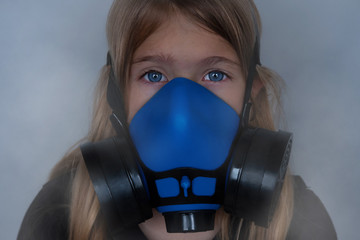 Young girl wearing gasmask, respirator portrait. Effects of worldwide air pollution, industrial...