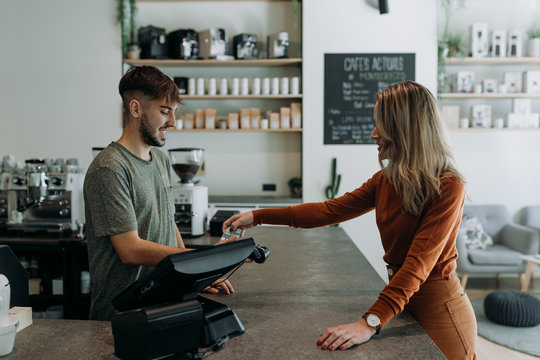 blonde woman paying in a cafe