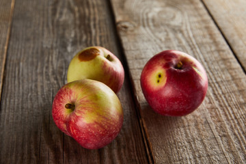 apples with rotten spot on wooden surface