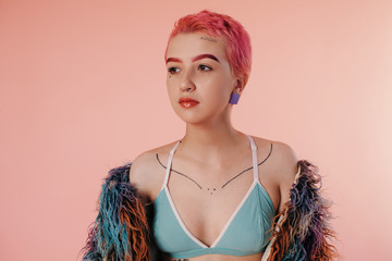 Portrait of teen girl with pink hair and tattoos