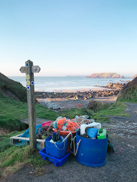 A pile of rubbish that has been washed up on. and collected from, a beach. It is mainly plastics.