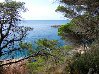 Paisaje de la Costa Brava catalana, España, con el mar azul, islas, aguas cristalinas, árboles y acantilados
