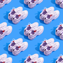 Pair of white sneakers on color background. Sport running concept. Many shoes seamless pattern