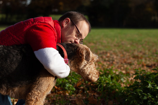 Man with down syndrome hugs his dog.