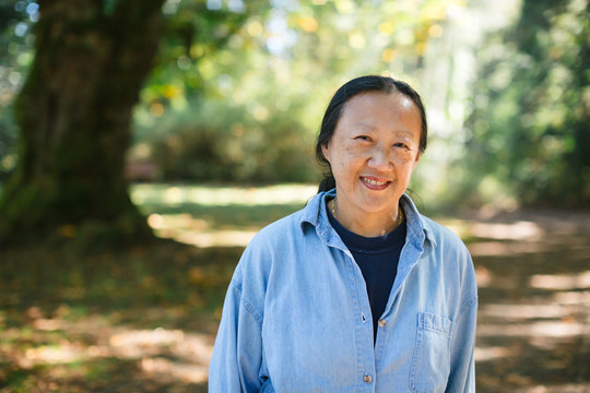 Mature asian woman practicing tai chi outside.