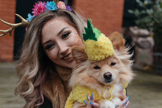 A girl in her twenties and her dog dressed up for halloween