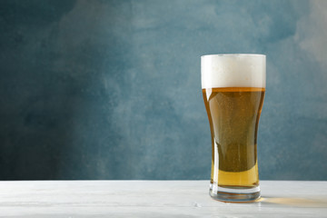 Mag with beer on wooden table, space for text