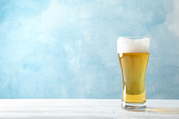 Mag with beer on wooden table, space for text