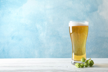 Mag with beer, spikelets and hop on wooden table, space for text
