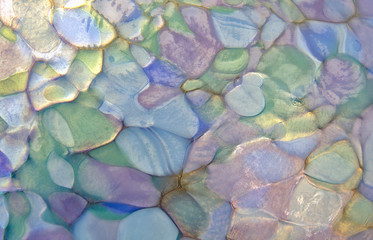 Macrophotograph of pastel colors and soft patterns in the surface of a hand-blow glass ball or orb.