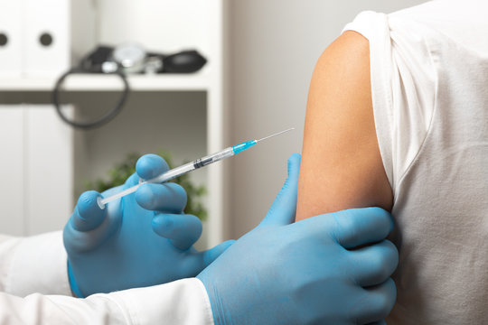 Doctor Giving Patient Vaccine, Flu Shot. Doctor Making A Vaccination In The Shoulder Of Patient