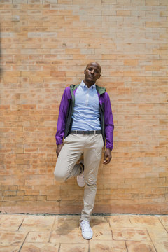 Black Man Leaning Against Clay Wall