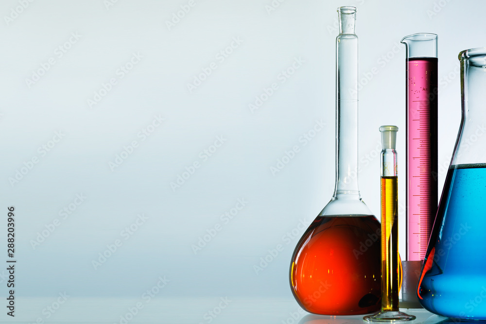 Wall mural different laboratory glassware with color liquid and with reflection