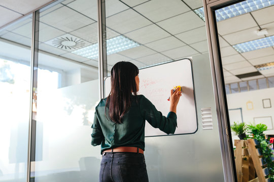 Woman Writing On Whiteboard In Office Room