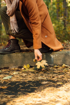 Crop woman taking leaf from path