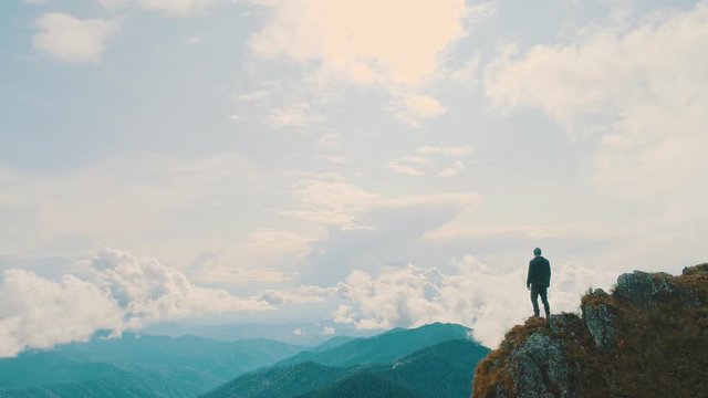 The man standing on a mountain cliff with a beautiful landscape
