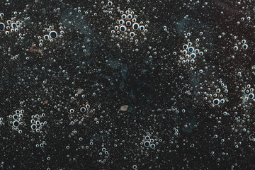  an abstraction depicting many small bubbles in the black wilderness. chaotic abstraction pattern. background