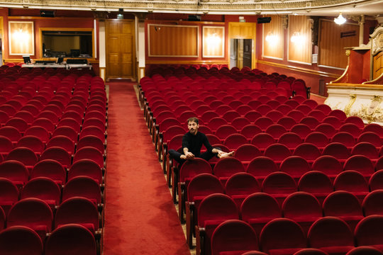 Male dancer sitting in theatre auditorium