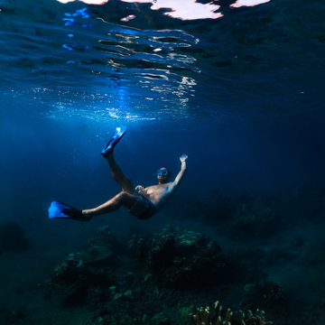 young guy in swimming goggles and snorkel, snorkeling in the Indian Ocean