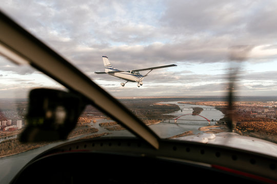 Retro biplane in flight above city