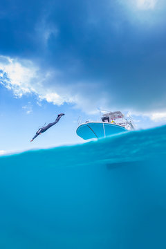 A male diving from the boat