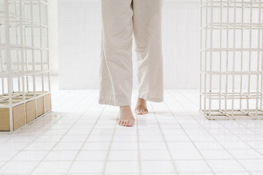 Barefoot Woman Standing on Tiles
