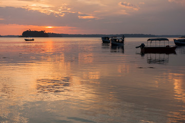 Fototapeta na wymiar Sunset on the coast of Andaman islands with the longboats