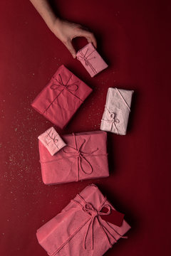 Hand holding gift box near row of presents