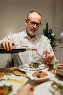 Elegant Senior man serving wine