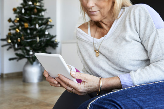 Faceless senior woman reading e-book.