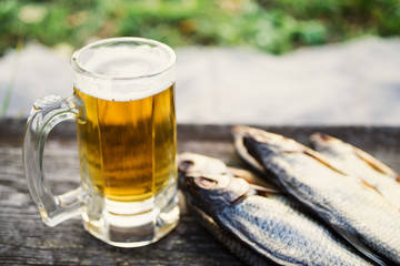 Glass of beer, salty fish on an old wooden table, soft focus. Beer and snack to beer.